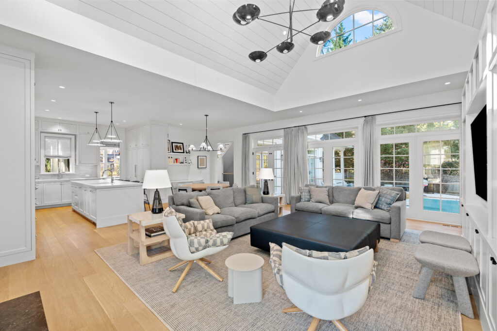 Family room in Bethesda luxury home, showing open kitchen layout and private pool through glass doors.